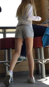 Gorgeous teen in shorts in a cafe
