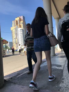 Cute Girl in a Short Denim Skirt Walking on a Street And Waiting on a Crosswalk Gallery