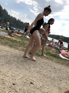 Cute Barefoot Girl in a Black Body Swimsuit Walking on a Road