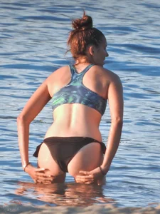 Sexy beach girl in a Nike sports bra and black bikini bottom