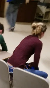 Blonde student in jeans showing her blue thong whale tail