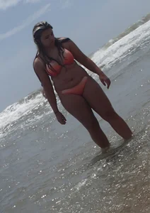 Thick beach girl with big boobs in a peach bikini