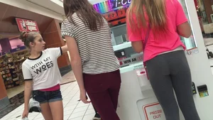 Little blonde teen in grey leggings at the mall with her friends