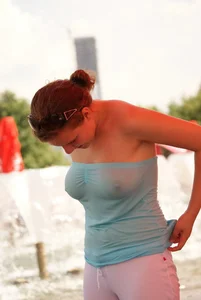 Big boobed girl in blue top with no bra playing in the water