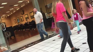 Little blonde teen in grey leggings at the mall with her friends