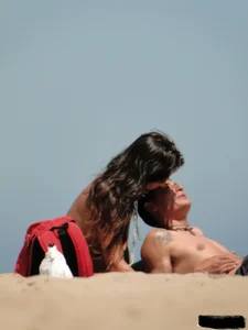 Topless lady on the beach in a gold thong with a nice ass