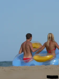 Sexy mom and daughter in red thongs at the beach
