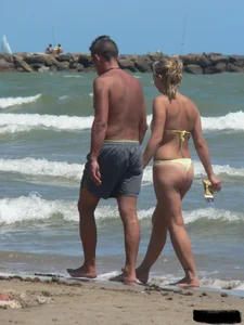 Sexy blonde on the beach in a yellow thong bikini