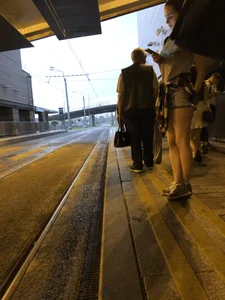 Cute Teen in Shorts on the Tram Stop