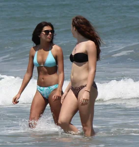 Brunette and redhead on the beach in bikinis looking sexy