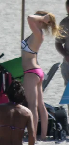 Skinny blonde girl on the beach in her pink and white bikini