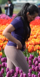 Cute babe in tight leggings taking pictures in flower fields