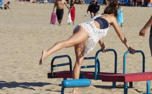 Beach teen in semi thong bikini under see through dress on the beach