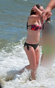 Cute beach girl in little bikini in the water