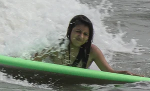 Brunette bikini girl on the beach and surfing in her bikini