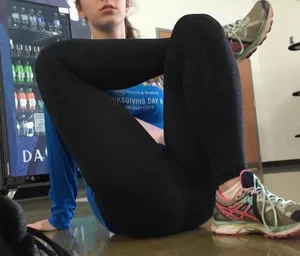 Teen Student Girl in Leggings Sitting on the Floor Crossing Her Raised Legs