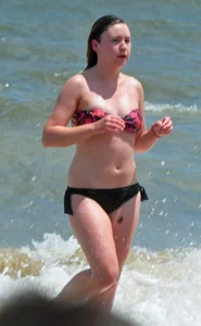 Cute beach girl in little bikini in the water