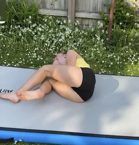 Young Athletic Barefoot Girl in Spandex Mini Shorts and a Top Laughing Her Ass Off While Doing Gymnastics