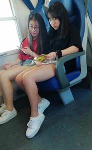 Two cute Asian teens on the bus in shorts showing their legs