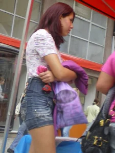 Redhead girl with her cheeks eating her denim shorts