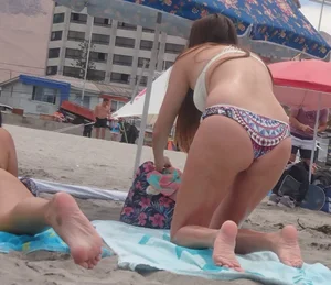 Pink and patterned bikini girls' asses laying on the beach