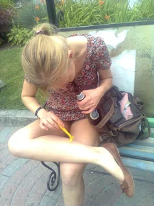 Girl in a Dress Shaving Her Legs on the Park Bench Photos