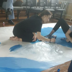 Skinny teen painting on the floor
