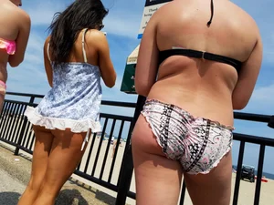 Trio of girls in bikinis on the beach and one with an incredible ass