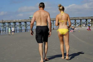 Skinny cute blonde on the beach in yellow bikini