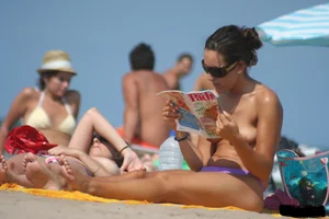 2 topless girls at the beach in thongs