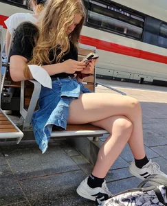 Candid Teen Girl With Awesome Legs in Shorts Sitting With Crossed Legs at the Railway Station Creepshots