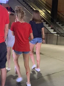 Bunch of girls in various outfits at a Cardinals baseball game