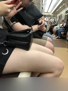 Cute pale teen in shorts in subway train, closeup of her legs