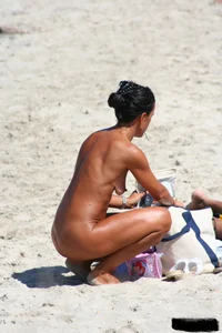 Smoking milf at a nude beach with a hairy pussy