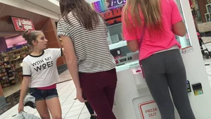 Little blonde teen in grey leggings at the mall with her friends