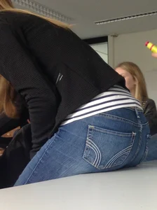 Candid college teen's booty in tight blue jeans closeups, placing her booty on top of desk