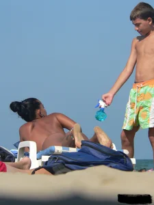Hot ass topless beach girl with great tits lets her little brother oil up her ass in thong bikini