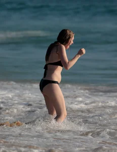 Cute bikini girl in the water in a black bikini