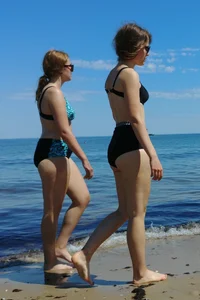 2 sexy friends in bikinis walking on the beach