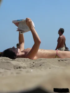 Topless beach milf looking sexy in a tiny g-string bikini
