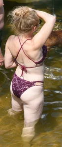 Chunky blonde enjoying some drinks in the water in her purple bikini