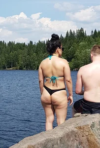 Thick brunette at the lake in a black thong bikini