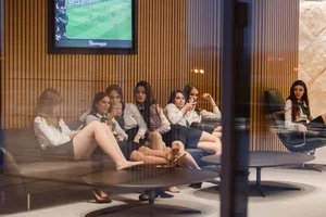Group of working girls in uniforms sitting with their legs on table