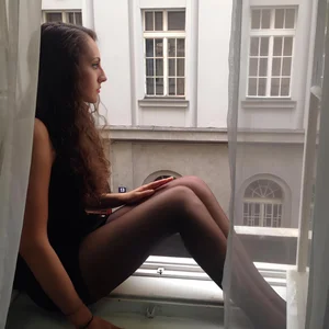 Girl with long hot legs in black pantyhose sitting on windowsill