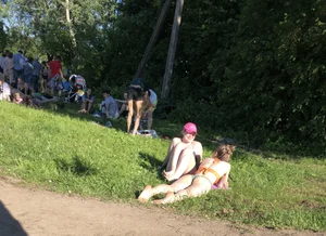 Two candid teens laying on the grass in the park
