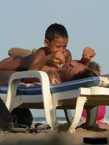 Topless tattooed lady on the beach with fake big tits