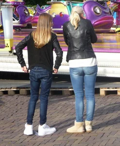 Skinny teen and her blonde mom wearing jeans at the amusement park