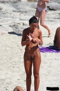 Smoking milf at a nude beach with a hairy pussy