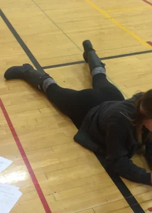 Girl in Leggings Lying on the Floor of the College Gymnasium With Spread Legs