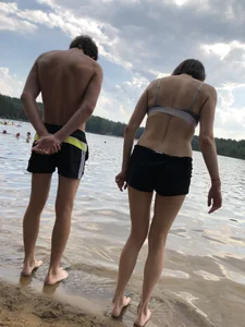 Girl With Thin Legs in Shorts and a Bra Afraid to Walk Into the Water